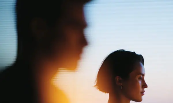 夕暮れの室内で話す人々のシルエット